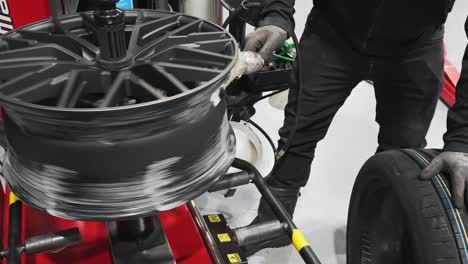 Car-mechanic-putting-tire-mounting-liquid-lube-on-aluminum-alloy-wheel,-Cinematic