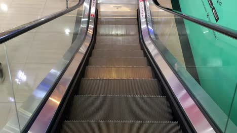 Indonesia---Aug-22,-2023-:-Moving-down-the-escalator-with-glass-sides-and-metal-steps