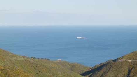 Un-Ferry-Navegando-En-Un-Océano-Tranquilo-Con-El-Paisaje-En-Primer-Plano
