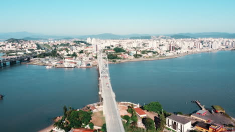 A-panoramic-drone-view-capturing-the-majestic-beauty-of-the-Hercílio-Luz-Bridge-in-Florianópolis,-an-iconic-landmark-against-the-coastal-backdrop