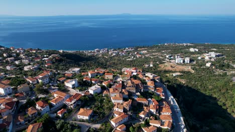 Mar-Azul-Y-Colinas-Verdes-Con-Pueblos-Turísticos-En-La-Riviera-Albanesa,-Lugar-Famoso-Para-Las-Vacaciones-De-Verano-En-El-Mediterráneo,-Gran-Oportunidad-Para-El-Sector-Inmobiliario.