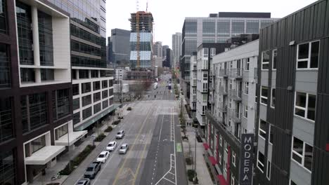 Aerial-track-down-a-mostly-deserted-city-street,-Seattle,-Washington,-cloudy