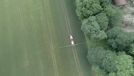 4K-Luftaufnahmen-Von-Traktoren,-Die-Feldfrüchte-Auf-Einem-Bauernhof-In-England-Besprühen