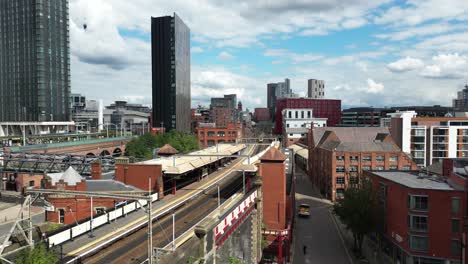 Aerial-drone-flight-passing-over-Deansgate-Train-Station-and-heading-over-the-rooftops-towards-Oxford-Road-in-Manchester-City-Centre