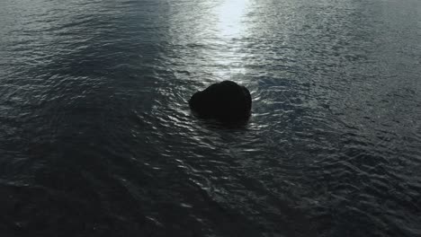 Aufnahme-Eines-Felsens-Im-Ozean,-Der-Sich-Vor-Der-Morgensonne-Abzeichnet