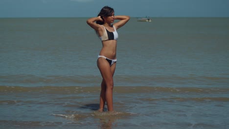 A-young-hispanic-girl-in-a-bikini-stands-in-the-ocean-on-a-sunny-day-in-Trinidad-and-Tobago