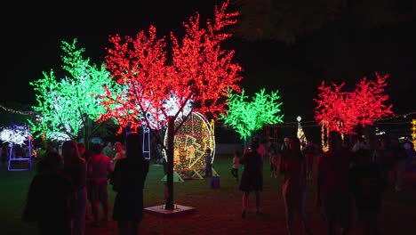 Pan-shot-of-people-walking-around-enjoying-lights-at-the-Christmas-in-the-Marianas,-Saipan,-USA