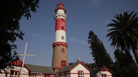 A-reveal-shot-of-the-Swakopmund-lighthouse-from-behind-leaves-of-a-tree