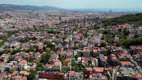 An-aerial-drone-shots-of-Catalonia-skyline-with-green-trees-and-Pyrenees-in-the-background