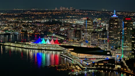 Vancouver-BC-Canada-Aerial-v3-hyperlpase-panoramic-view-capturing-shipyard,-illuminated-harbor,-landmark-Canada-Place-and-waterfront-downtown-night-cityscape---Shot-with-Mavic-3-Pro-Cine---July-2023