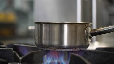 Die-Flamme-Auf-Dem-Küchengerät-Schafft-Eine-Heiße-Kochatmosphäre-In-Der-Kulinarischen-Szene-Der-Heimischen-Küche:-Brennende-Flamme-Auf-Dem-Herd,-Kochgeschirr,-Küchenutensilien,-Heiße-Kochumgebung