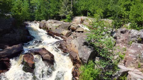 Drone-footage-of-a-flight-over-the-falls-of-a-river-flowing-through-the-forest