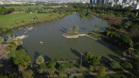 Flight-over-the-lake-of-Ganei-Yehoshua-Park,-you-can-rent-pedal-boats-and-have-a-picnic-on-the-shores-of-the-lake