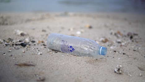 Botella-De-Plástico-Vacía-Tirada-En-La-Arena-De-La-Playa