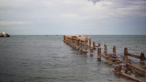 Un-Antiguo-Muelle-De-Pesca-En-La-Bahía-De-Prachuap-Khiri-Khan-En-Hua-Hin,-Tailandia,-Dañado-Por-El-Clima-Severo-Que-Azota-La-Costa
