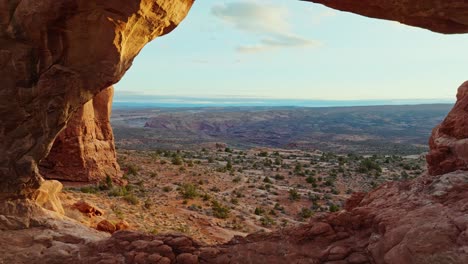 Desert-Landscape-Seen-Through-The-Hole-Of-Natural-Sandstone-Arch-In-Arches-National-Park-In-Utah,-United-States