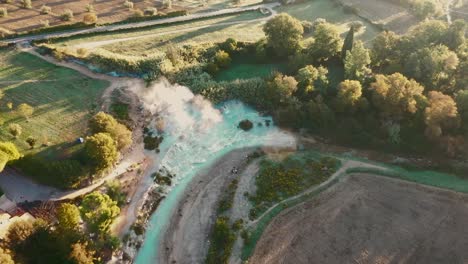Cascate-del-Mulino,-Soothing-Natural-Hot-Springs-Bath,-Saturnia,-Tuscany,-Italy,-Europe,-Drone-view-traveling-forward,-tild-down