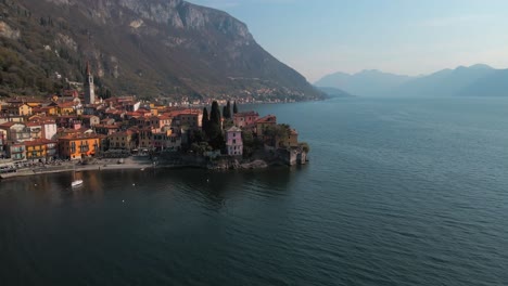 cinematic-pull-around-shot-of-verenna-in-italy-overlooking-lake-como-during-the-sunset-emitting-a-chill-and-calm-vibe-down-on-the-lakes-edge