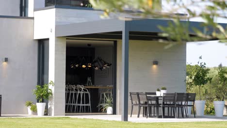 Slow-revealing-shot-of-a-modern-white-villa-with-garden-seating-under-a-canopy