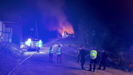 First-responders,-firefighters-and-police-looking-at-a-burning-house-after-being-to-late