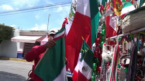 A-street-vendor-displaying-a-Mexican-flag-for-sale