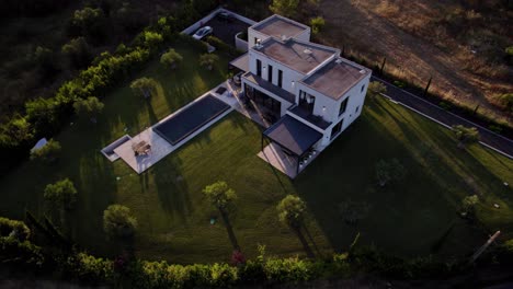Aerial-establishing-shot-of-a-modern-countryside-villa-with-a-swimming-pool-in-Uzes