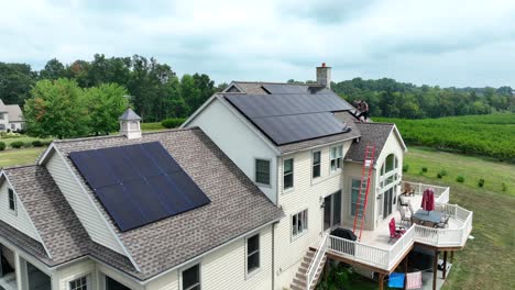 Young-males-installing-solar-panels-on-large-American-home