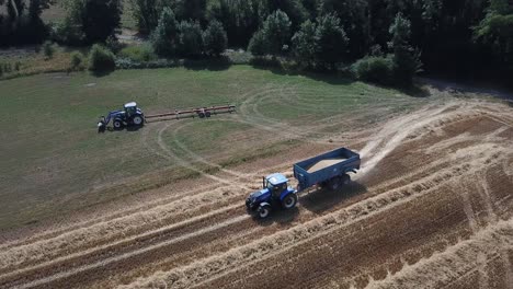 A-cinematic-4K-drone-shot-of-two-tractors-working-on-a-field-in-France,-showcasing-agriculture-with-an-epic-view-and-dramatic-dust