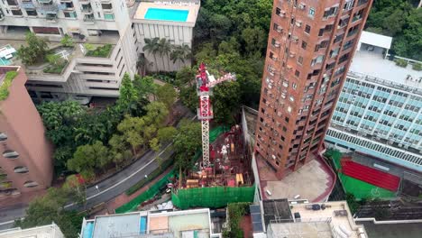 Top-Down-View-of-Compact-Residential-Construction-Site-with-Tower-Crane-Among-High-Rises