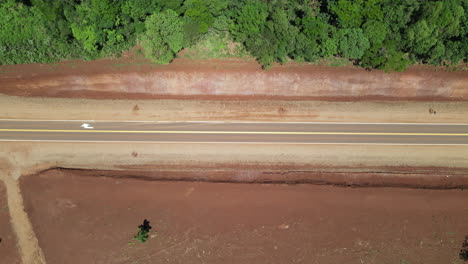 Road-dividing-jungle-from-red-earthed-countryside