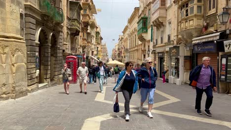 Menschen,-Die-An-Einem-Sonnigen-Tag-In-Valletta-Auf-Einer-Von-Gebäuden-Gesäumten-Straße-Spazieren