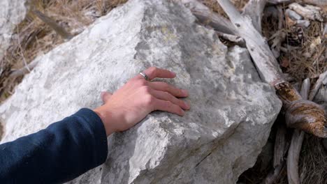 Slow-motion-close-up-shot-of-a-man-using-both-hands-to-climb-up-a-steep-hiking-route