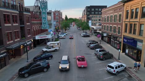 Red-antique-car-driving-on-North-Broadway-Street-in-Fargo,-North-Dakota-past-the-Fargo-Theater