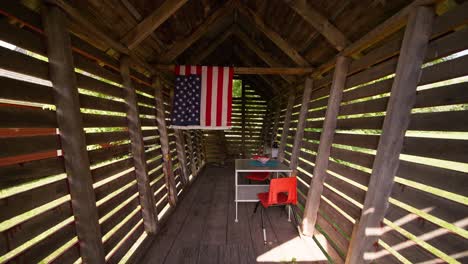 Push-in-wide-shot-of-an-outdoor-kids-playroom-with-a-table-and-chairs-and-an-American-flag-hanging