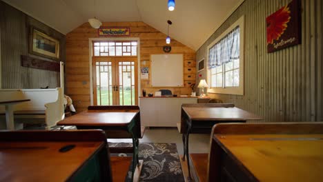 push-in-shot-down-the-row-of-vintage-school-desks-in-an-old-school-house-classroom