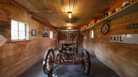 push-in-shot-of-a-vintage-tractor-inside-the-barn-of-a-garage-with-old-memorabilia-on-the-walls