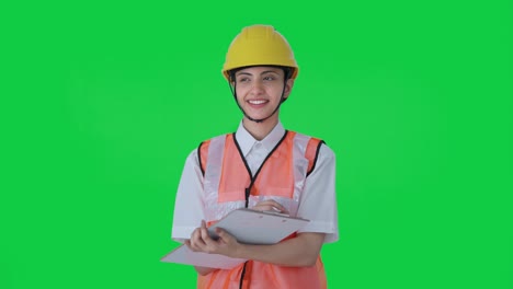 Happy-Indian-female-architect-taking-notes-in-building-Green-screen