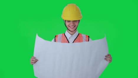 Happy-Indian-female-architect-looking-through-the-blueprint-Green-screen
