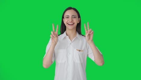 Happy-Indian-woman-pilot-showing-victory-sign-Green-screen