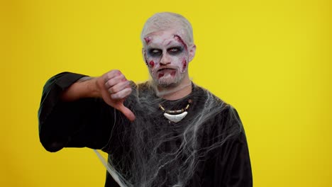 Sinister-man-Halloween-zombie-showing-thumbs-down-sign-gesture,-disapproval,-dissatisfied,-dislike