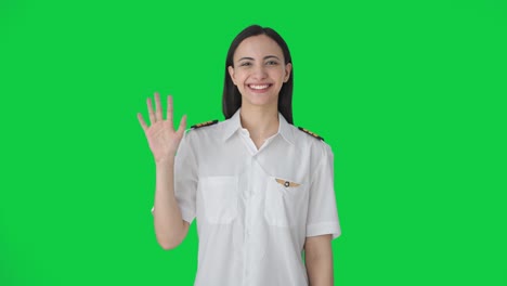 Happy-Indian-woman-pilot-waving-Hi-to-the-camera-Green-screen
