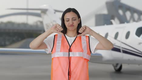 Disappointed-Indian-airport-ground-staff-girl-showing-thumbs-down