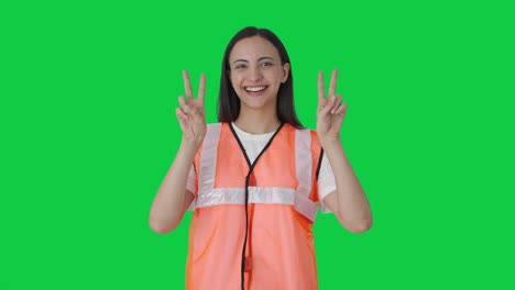 Happy-Indian-airport-ground-staff-girl-showing-victory-sign-Green-screen