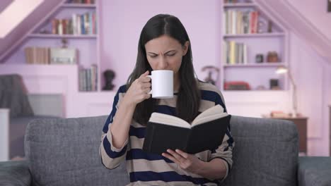 Verwirrtes-Indisches-Mädchen,-Das-Buch-Liest-Und-Kaffee-Trinkt