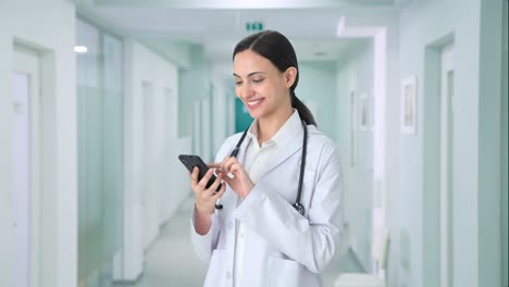 Happy-Indian-female-doctor-using-phone