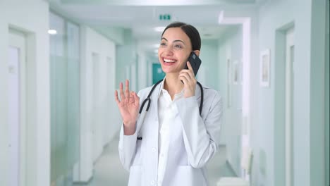 Happy-Indian-female-doctor-talking-to-someone-on-call