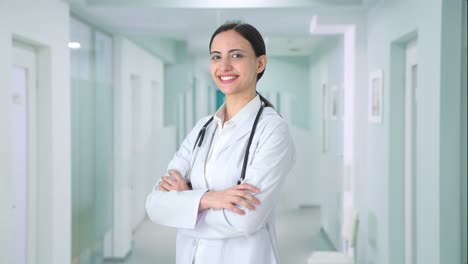 Portrait-of-Happy-Indian-female-doctor-standing-crossed-hands