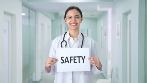 Happy-Indian-female-doctor-holding-SAFETY-banner