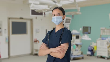 Indian-female-doctor-standing-crossed-hands-with-mask-on