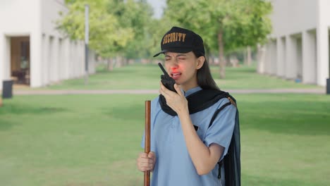 Indian-female-security-guard-talking-through-walkie-talkie
